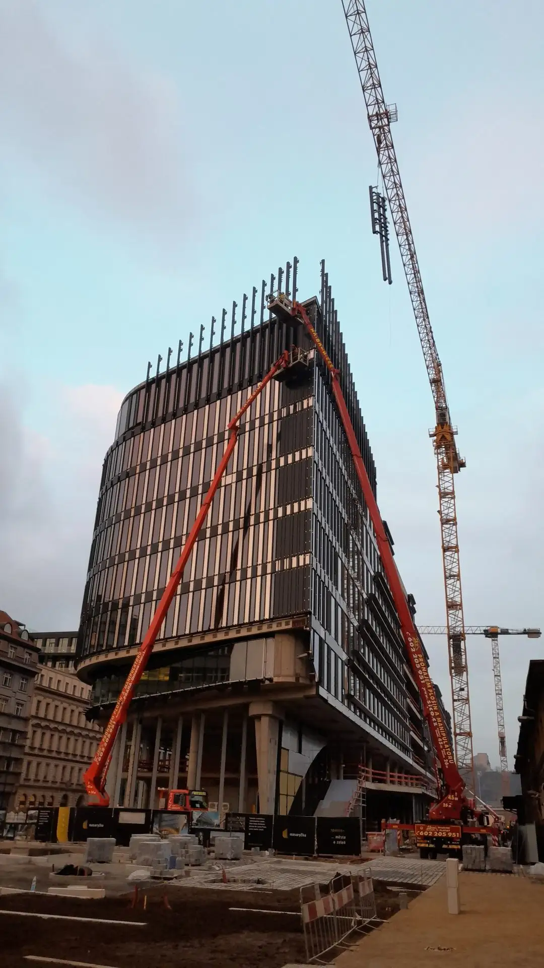 Montáž fasádních panelů z jeřábu, Masaryk centrum Praha
